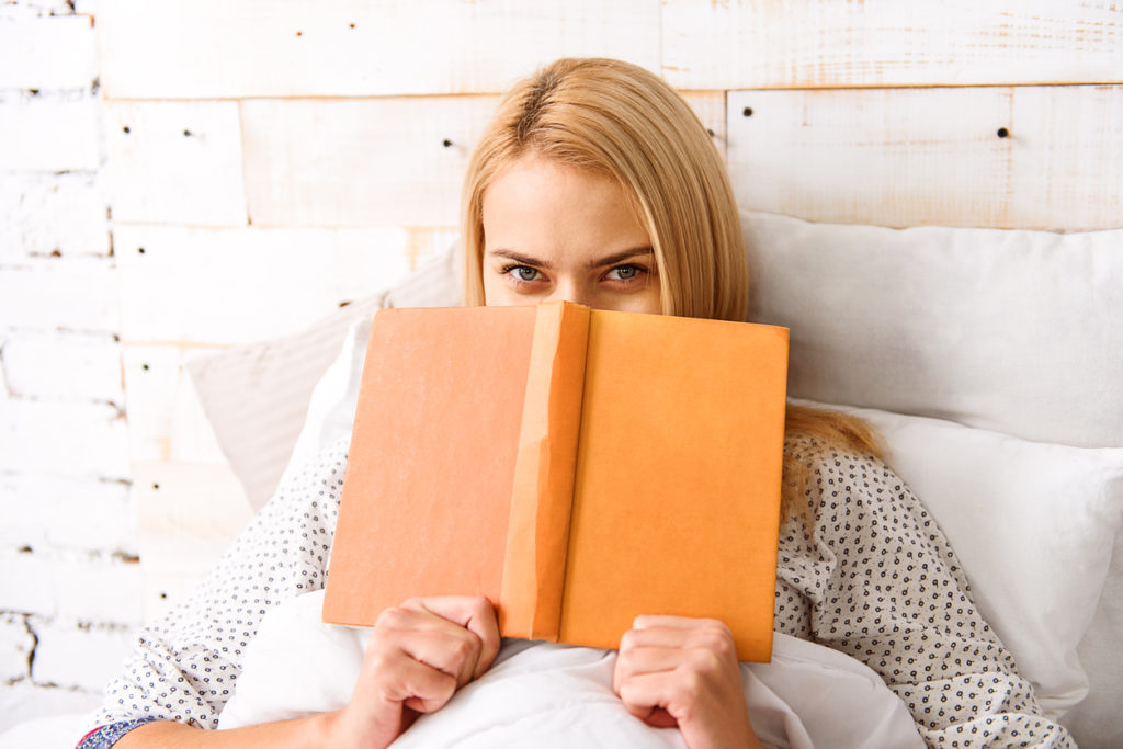woman in bed with book