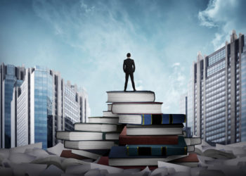 business man standing on books