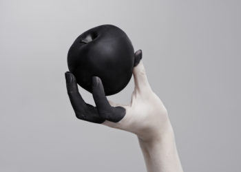 hand holding a black apple