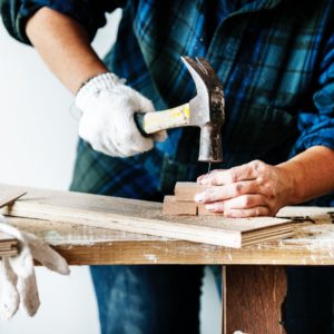 Human construction worker using hammer and nail.