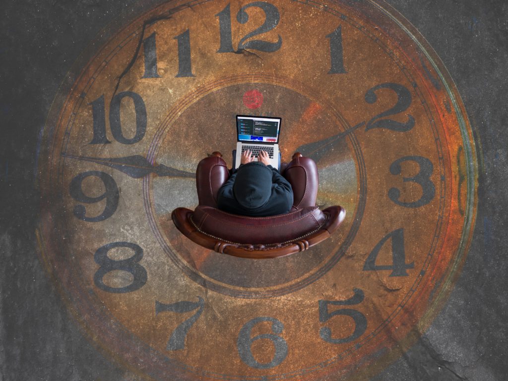 Photo of a person with a laptop sitting on a clockface