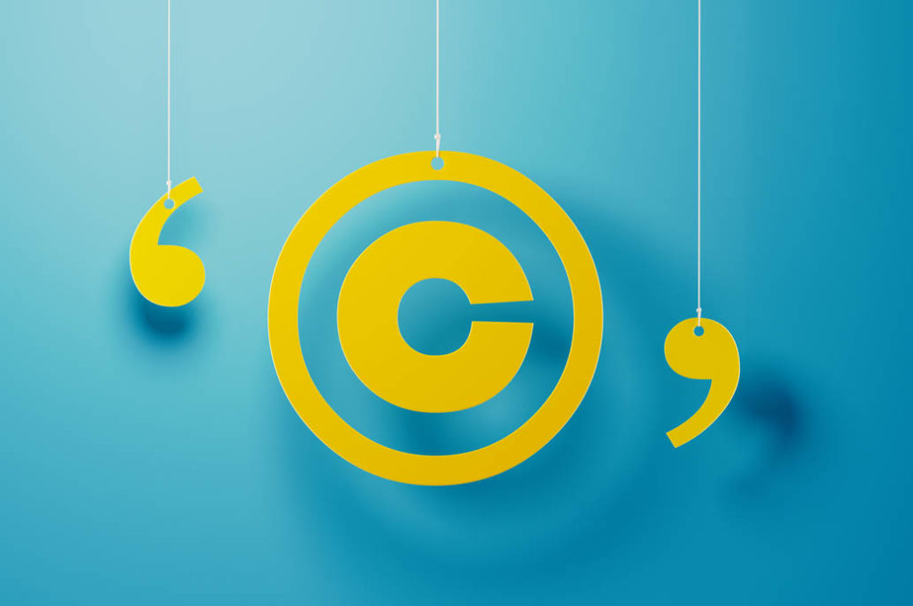Yellow copyright symbol with string hanging over blue background. 