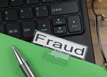 Folder labeled Fraud over a computer keyboard