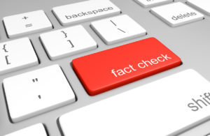 computer keyboard with one red key labeled for fact checking.