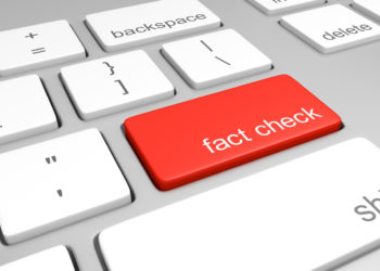 computer keyboard with one red key labeled for fact checking.