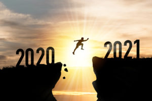 Silhouette Man jumping from 2020 cliff to 2021 cliff