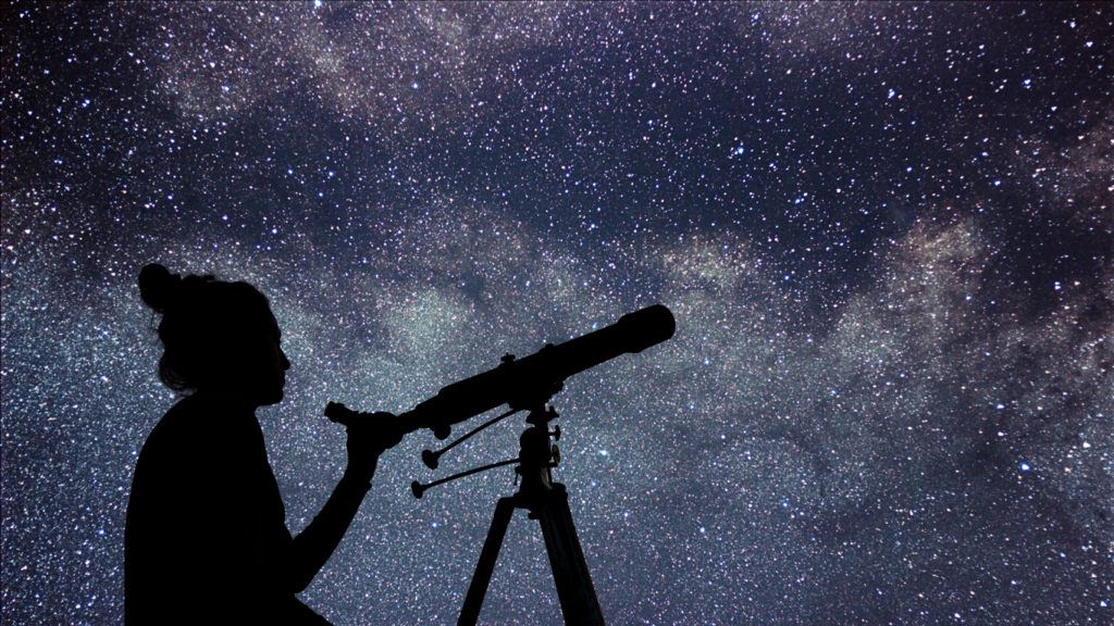 Woman with telescope watching the stars. 