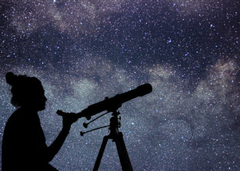 Woman with telescope watching the stars.