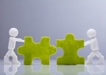 Human Figures Solving Green Jigsaw Puzzles On Grey Background