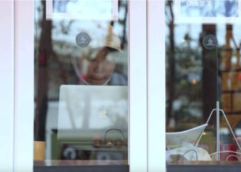 cafe patron writing as seen through a window