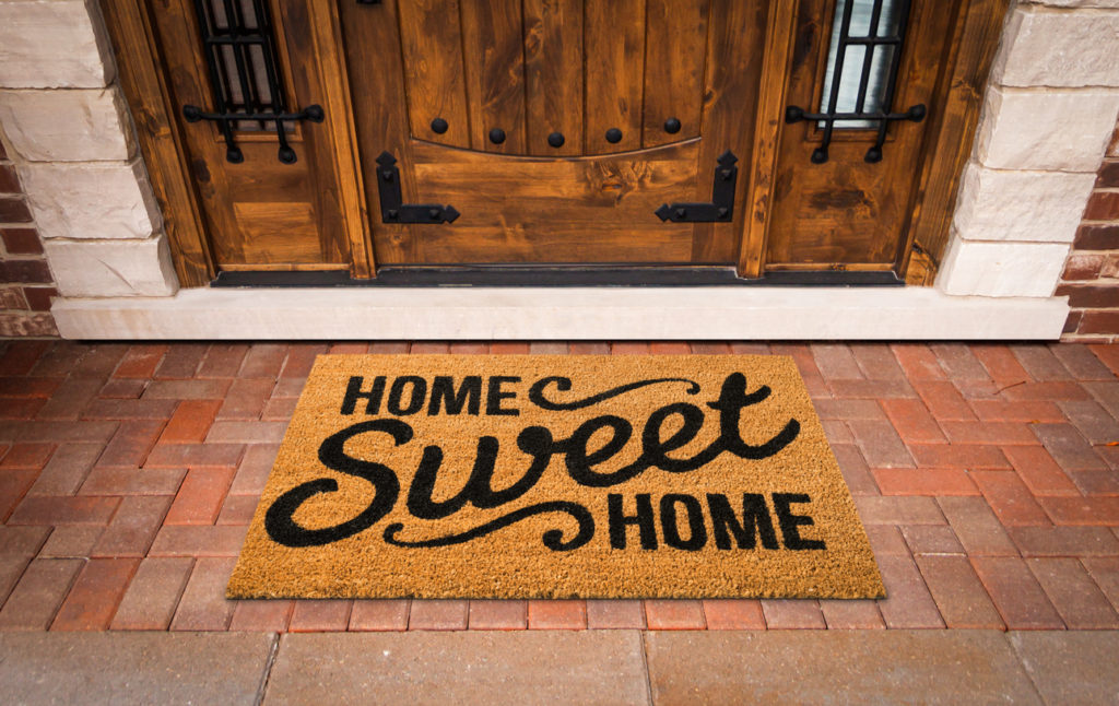 Home Sweet Home Welcome Mat At Front Door of House.