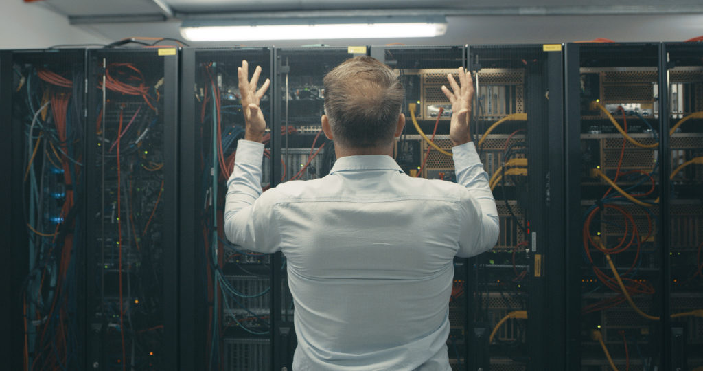 man looking stressed while working in a data center