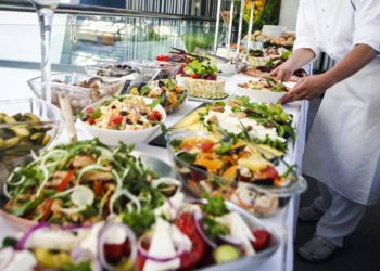 waiter placing food on a buffet table