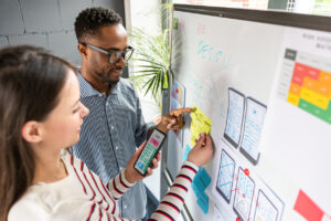 Designers at a whiteboard planning UX app development