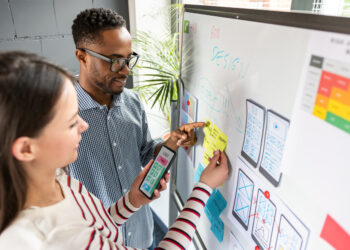 Designers at a whiteboard planning UX app development