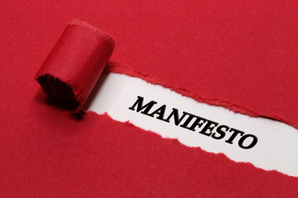 The word Manifesto Written Under Red Torn Paper