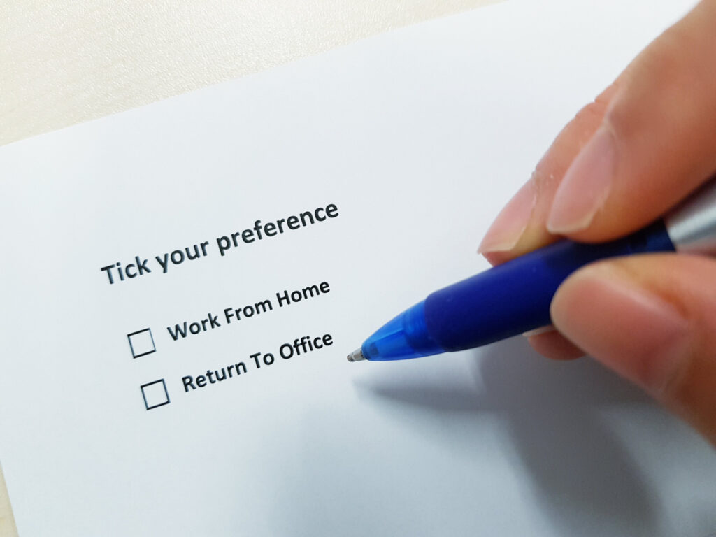 hand holding pen over form asking reader to tick  box to choose between working from home or returning to the office