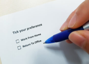 hand holding pen over form asking reader to tick box to choose between working from home or returning to the office
