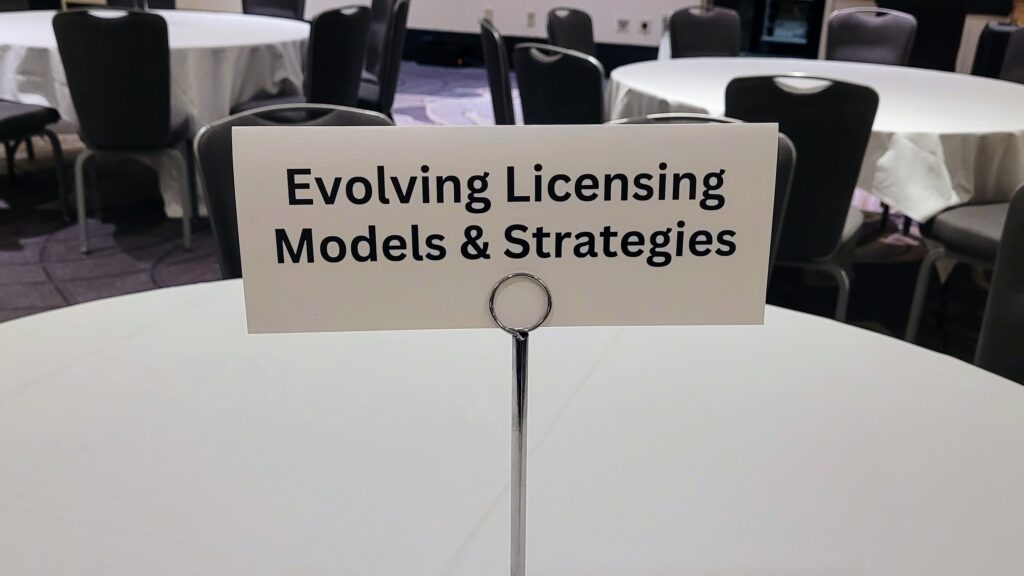 Photo of table placard that says "Evolving Licensing Models & Strategies"