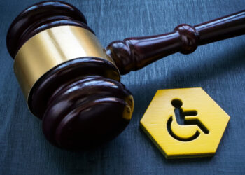A gavel and a disability person sign