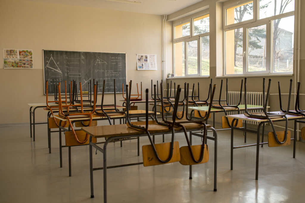 empty classroom with chairs stacked on top of desks