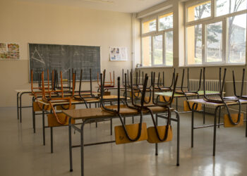 empty classroom with chairs stacked on top of desks