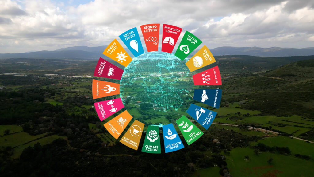 sustainable development goals symbols over a landscape photograph