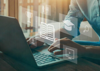 Digital graphic of human hands on a laptop keyboard with floating images of a book, trophy, graduation cap, and computer screen hovering above the laptop.