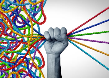 Hand grasping multicolored yarn, where the threads are taught on one side and tangled on the other side of the hand.