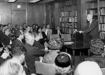 Black and white archival photograph of J. Robert Oppenheimer speaking at the dedication of the Niels Bohr Library in its new reading room at the American Institute of Physics headquarters in New York City, September 26h, 1962.