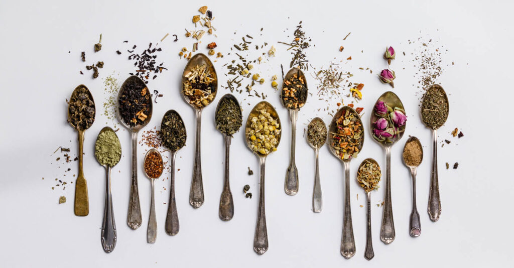 Assortment of dry tea in vintage spoons.