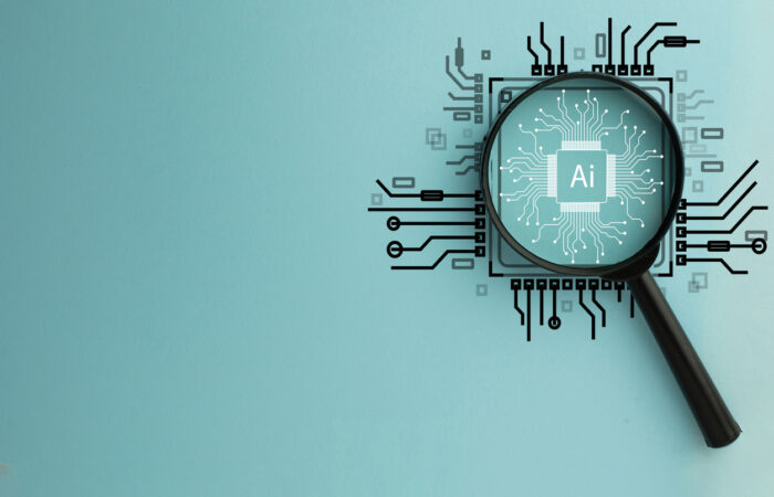 Magnifying Glass Focused on Circuit Board with AI Word, Representing Artificial Intelligence used for content discovery and search.