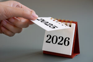 hand flipping calendar page turning from 2025 to 2026,