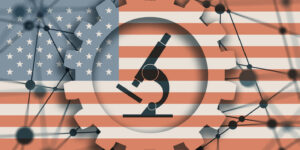Microscope icon surrounded by gear shapes all on a background of a US flag