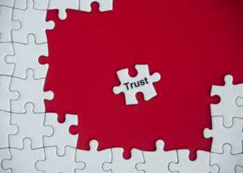 decorative image depicting the business concept of trust, with the word "Trust" on missing jigsaw puzzle