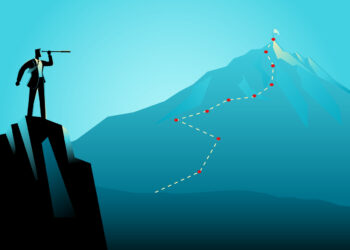 businessman on top of the rock using telescope looking to the top of a mountain