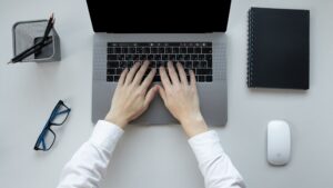 overhead view of hands placed on a laptop keyboard
