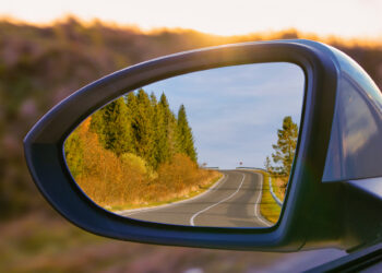 view of mountains in a car's side rear view mirror