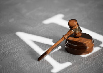 Image of a gavel with the letters AI projected on the surface beneath it