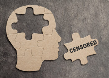 Conceptual image of a jigsaw puzzle in the shape of a human profile with a central piece removed and labeled CENSORED